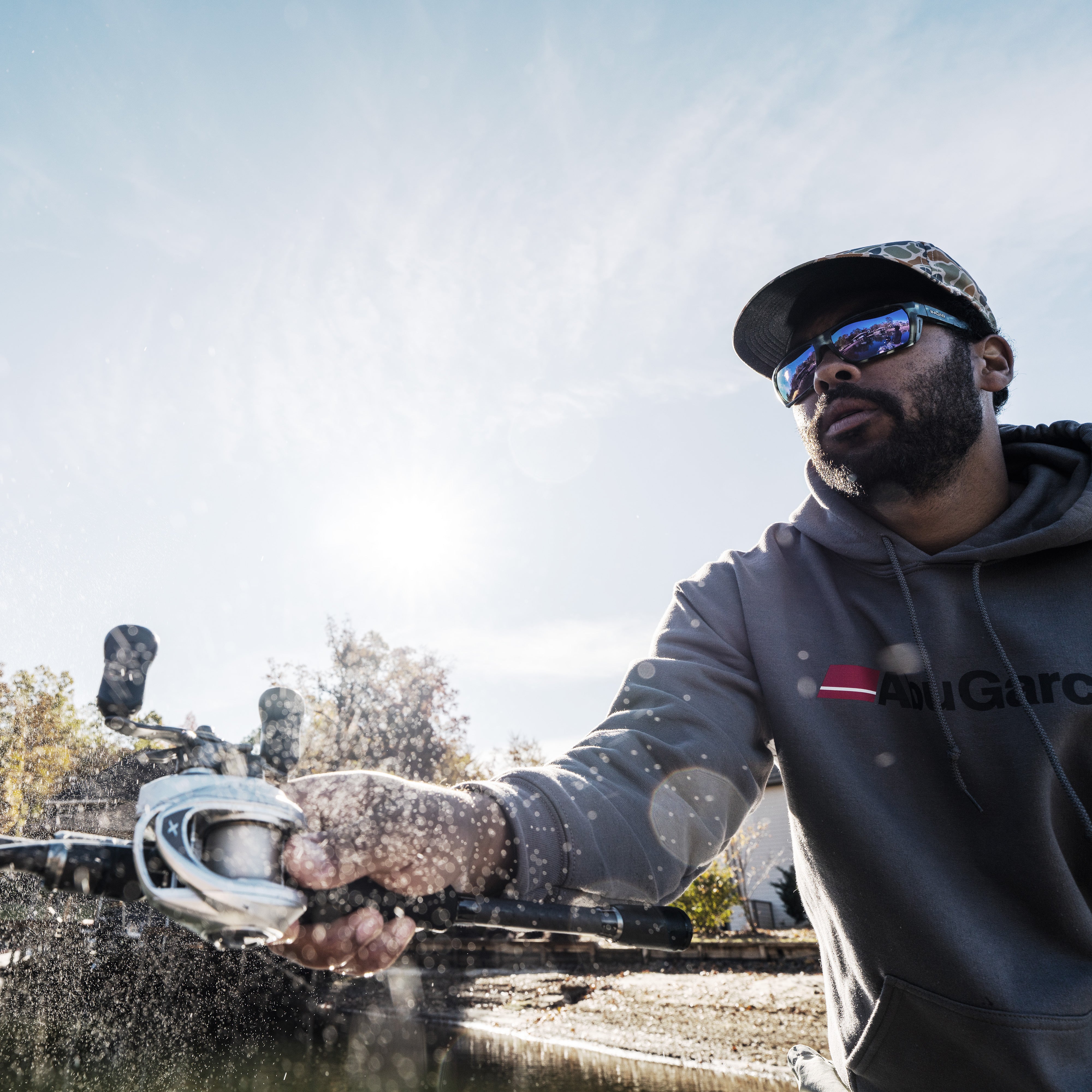 Man wearing Abu Garcia branded gear castsing a  Revo® VoltiQ™ Low Profile Reel over water.