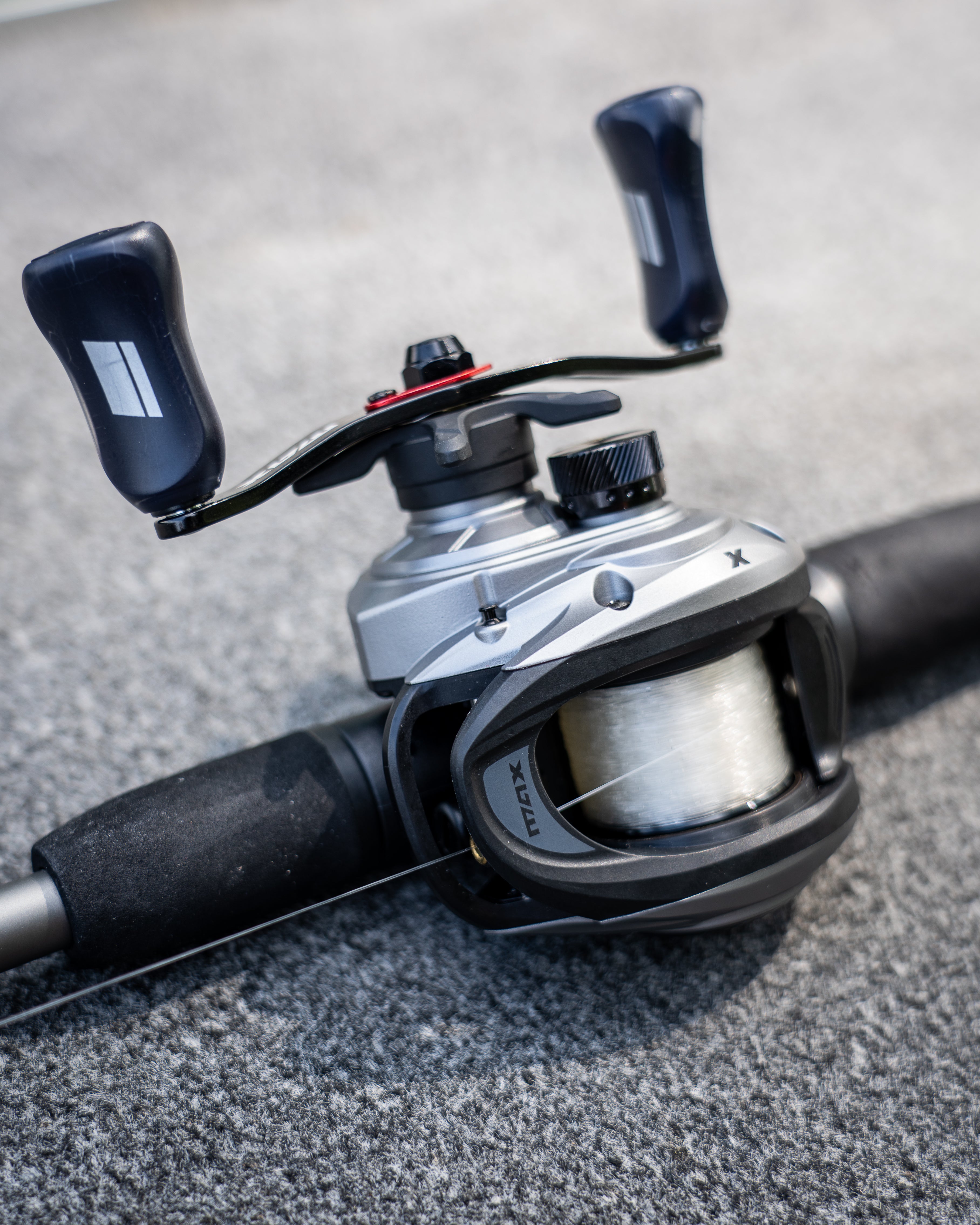 Abu Garcia Max X Low Profile Baitcast Combo laying flat on concrete. 