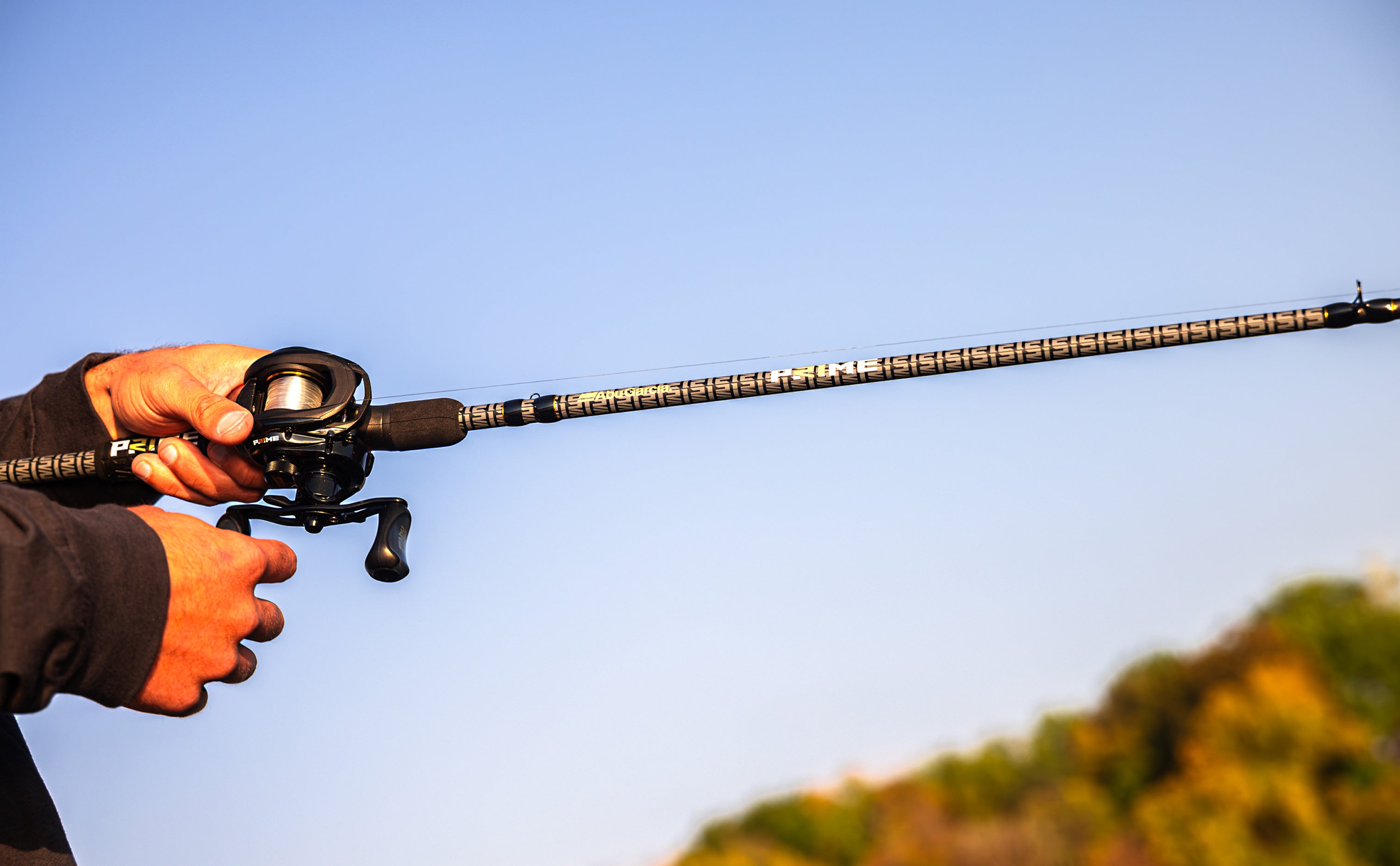 Fishing rod held by a person against a clear blue sky