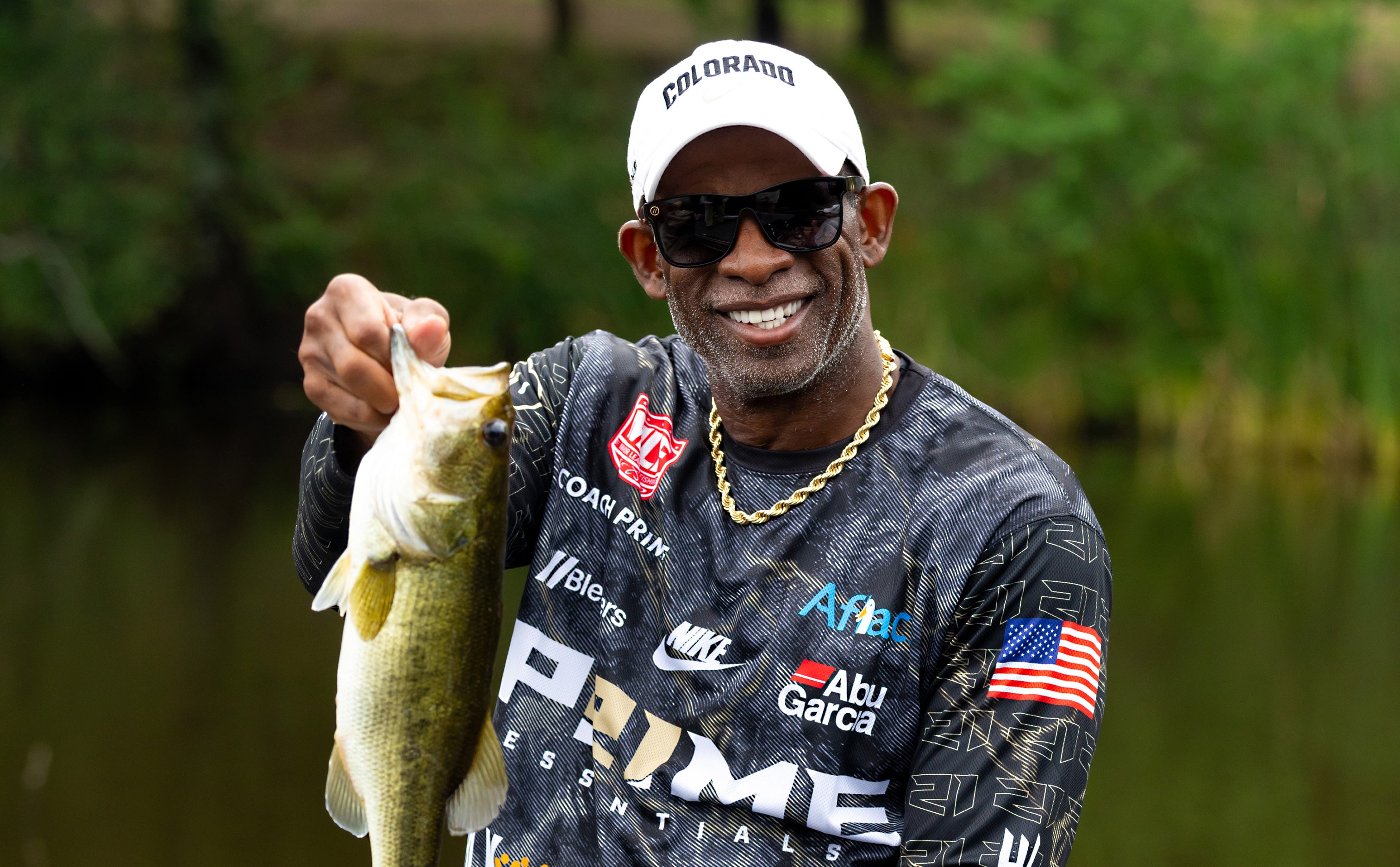 Man holding a fish with a blurred natural background